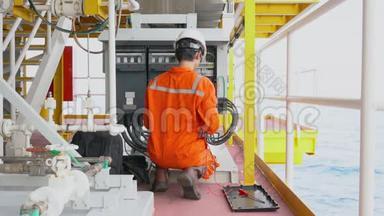 电气技术员打开海上油气生产平台上的电力系统检修配电箱